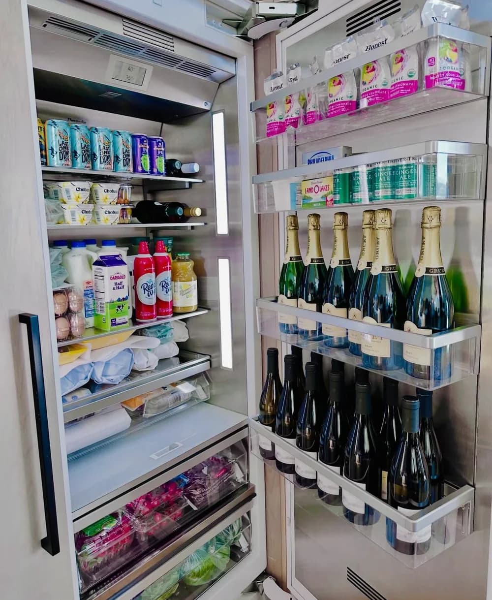 A stocked refrigerator with refreshments ready for arriving guests